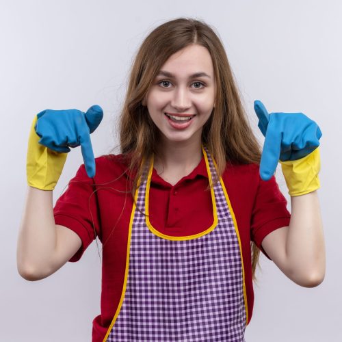 young beautiful girl in apron and rubber gloves smiling pointing with fingers down standing over white background young beautiful girl in apron and rubber gloves smiling pointing with fingers down standing over white background